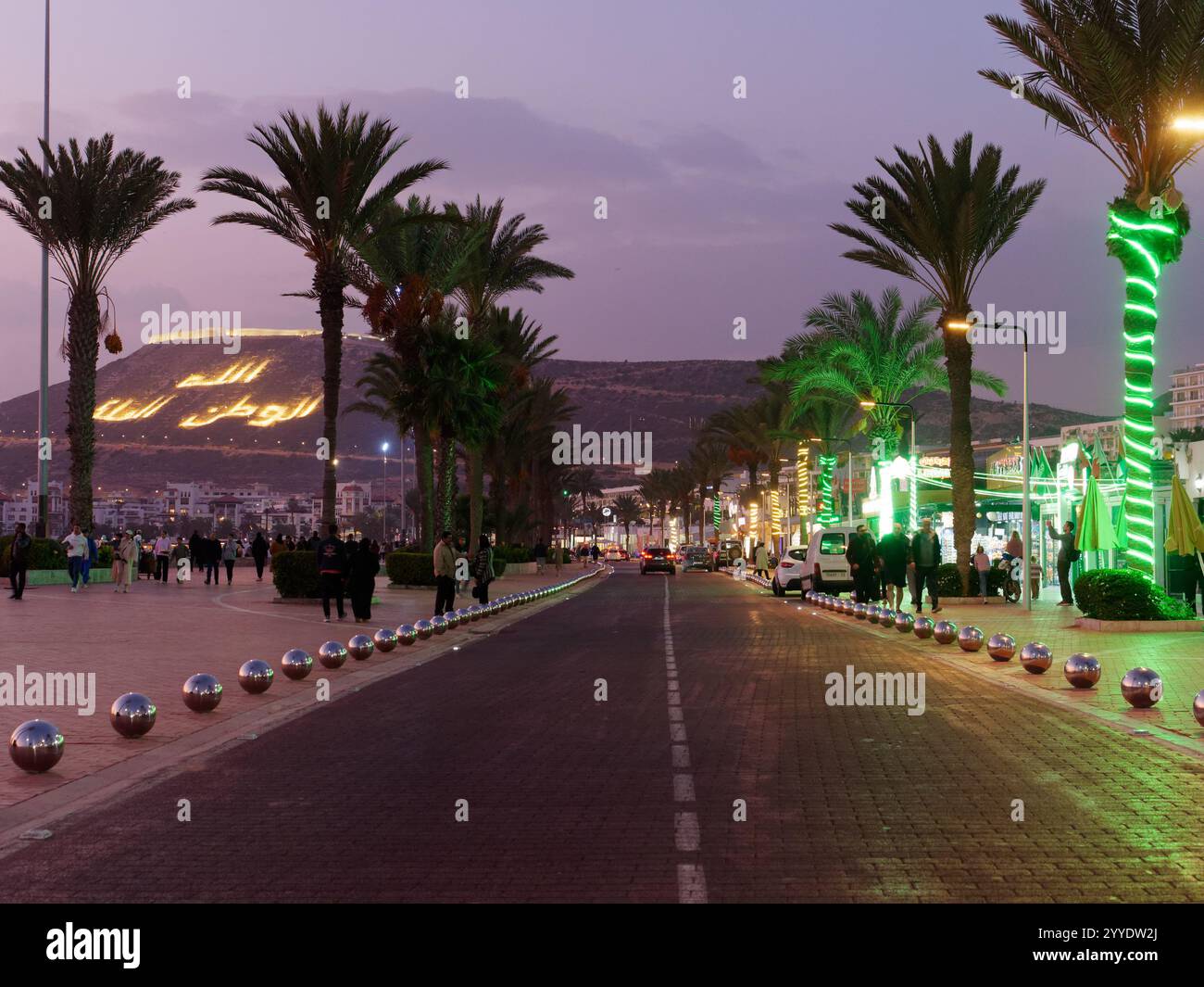 Straße neben der Promenade mit Palmen in Agadir mit der Kasbah (Fort) von Agadir Oufla dahinter. Stadt Agadir, 21. Dezember 2024 Stockfoto