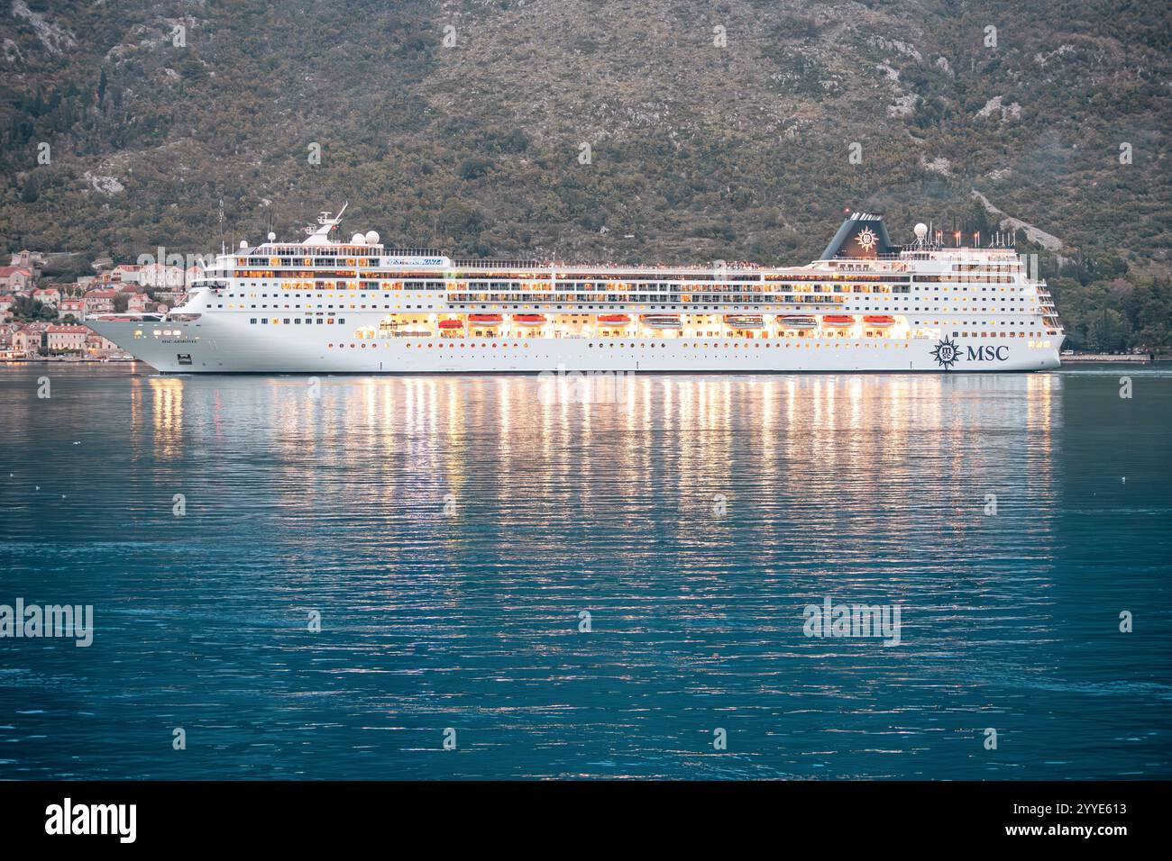 24. Oktober 2024, Kotor Bay, Montenegro: MSC Armonia Kreuzfahrtschiff auf ruhigem Wasser in der Abenddämmerung in der Nähe der Küstenstadt Stockfoto