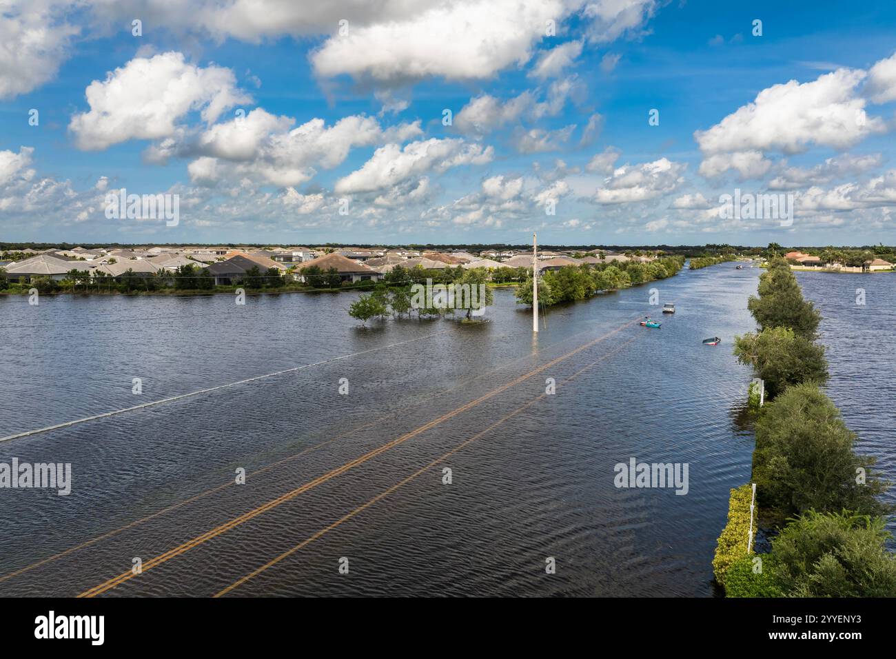 Überflutete Florida Straße mit festgefahrenem Auto nach Hurrikan Debby Regen umgeben von Wasser. Folgen von Naturkatastrophen Stockfoto