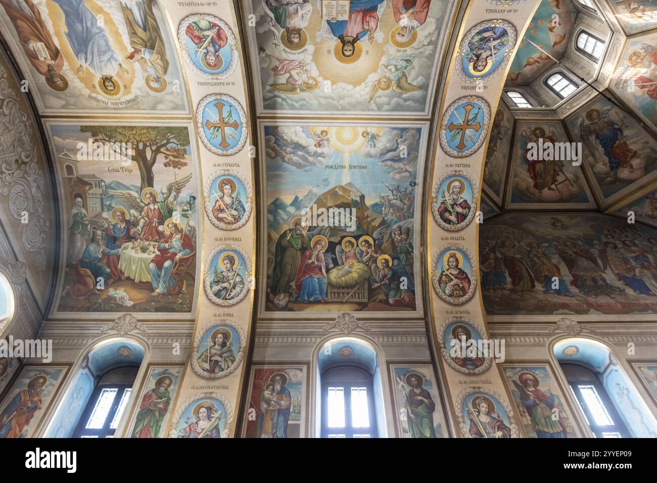 Die Decke einer Kirche ist mit vielen Gemälden religiöser Figuren verziert. Die Gemälde sind sehr detailliert und farbenfroh, und sie schaffen einen Sinn o Stockfoto