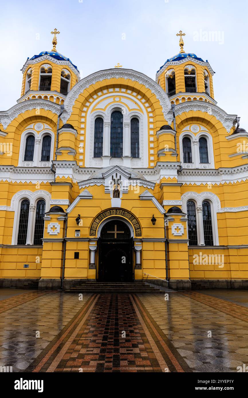 Die gelbe Kirche hat ein blaues Kreuz auf der Vorderseite. Das Gebäude ist sehr groß und hat viele Fenster Stockfoto