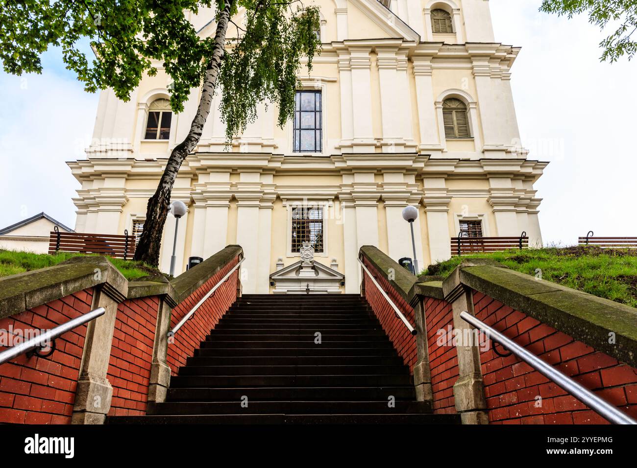 Ein großes weißes Gebäude mit einer roten Ziegelfassade und einem Baum davor. Das Gebäude hat viele Treppen, die hinauf führen Stockfoto