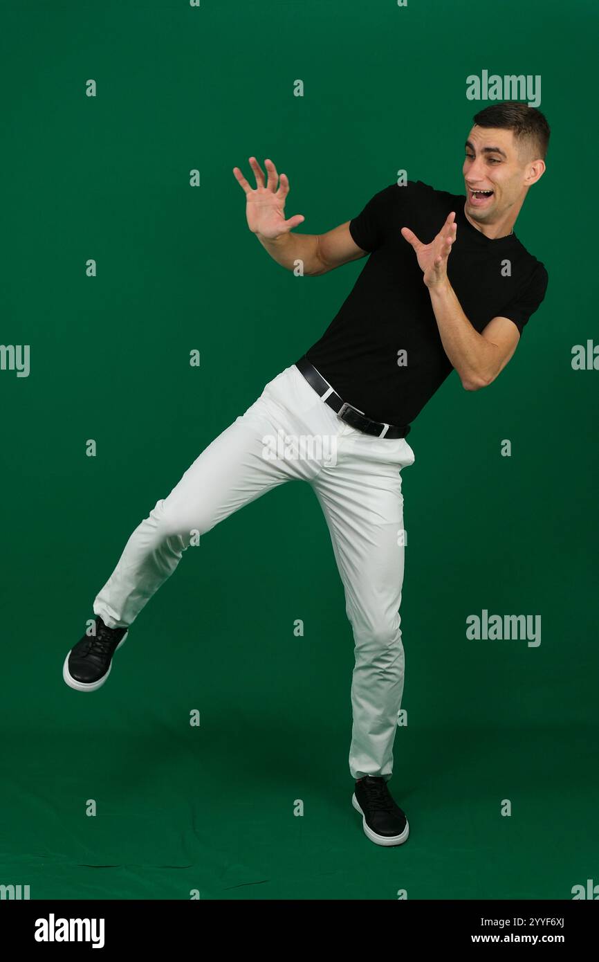 Mann in stilvollem Outfit, der auf blauem Hintergrund tanzt. Hochwertige Fotos Stockfoto