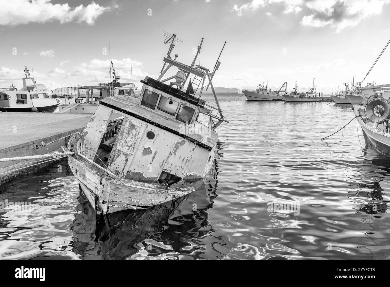Schwarz-weiß Blick auf ein altes Holzboot in sehr schlechtem Zustand im Hafen von Calasetta, Sardinien, Italien Stockfoto