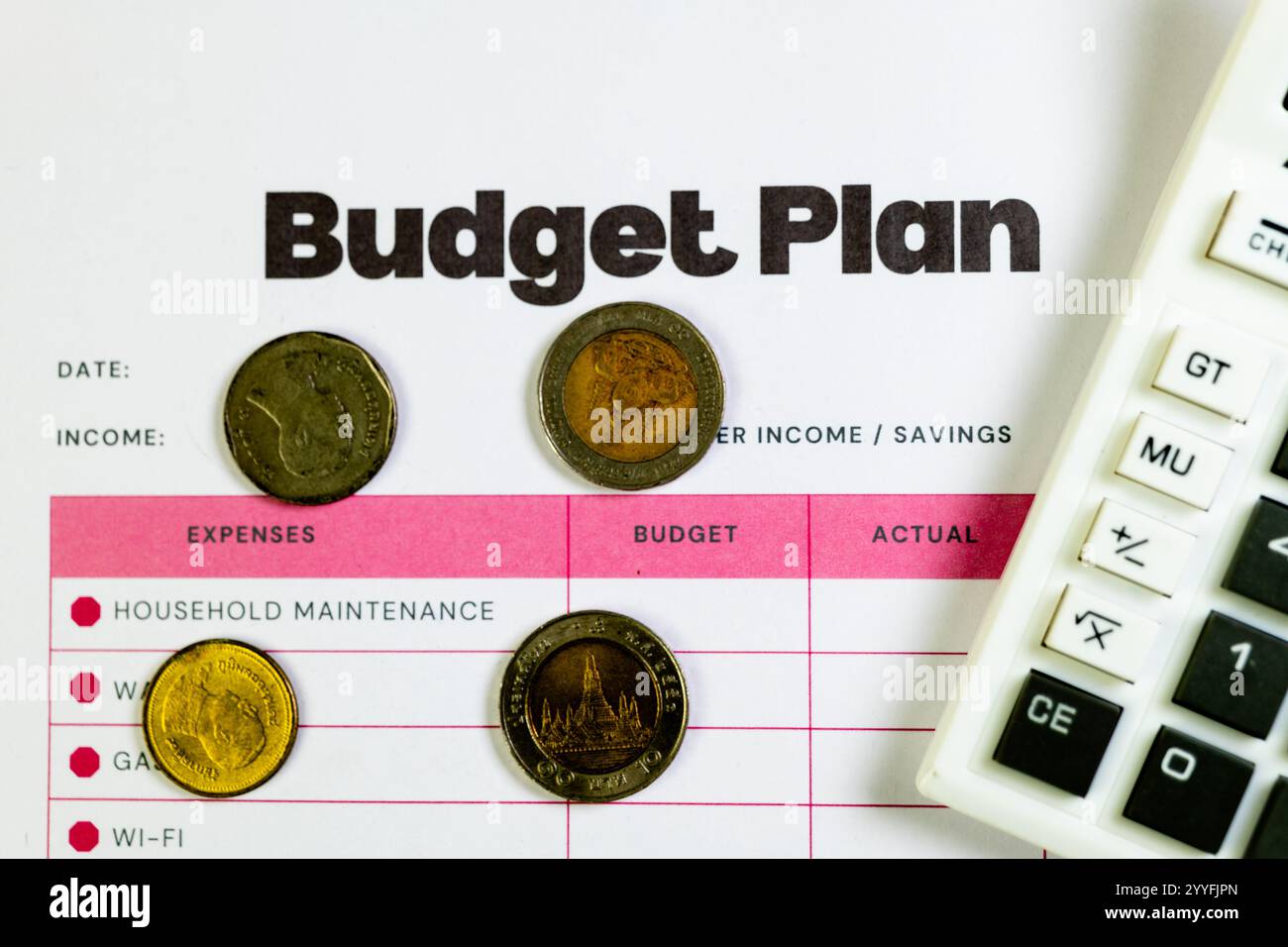 Planung eines Haushaltsbudgets mit Thai-Baht-Münzen und Taschenrechner. Verfolgen Sie Ausgaben und verwalten Sie Finanzen effektiv. Stockfoto