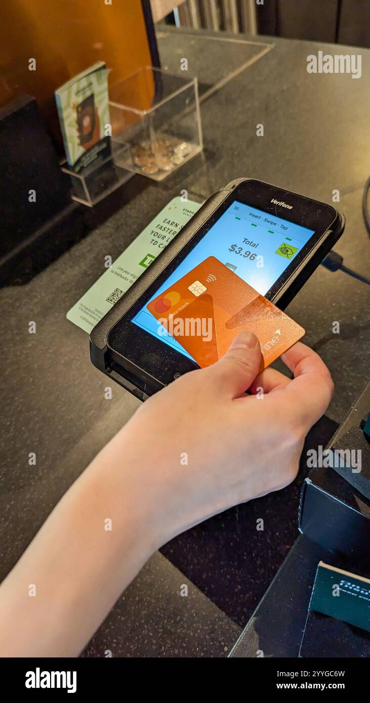 Eine Frau, die beim Starbucks Kaffee bezahlt Stockfoto