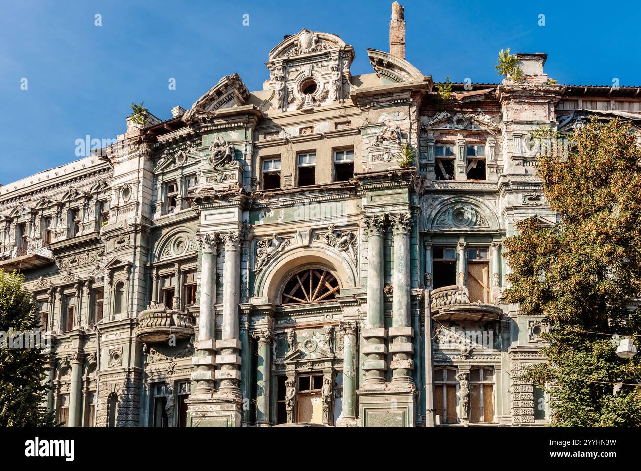 Ein großes Gebäude mit vielen Fenstern und Balkon. Das Gebäude ist alt und hat viel Schaden Stockfoto