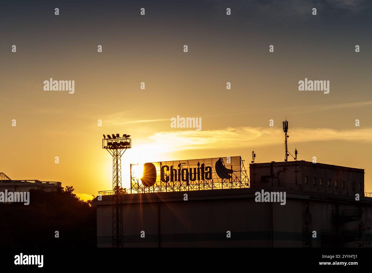 Vor einem Gebäude befindet sich eine Werbetafel für Chiquita. Die Sonne untergeht und strahlt ein warmes Leuchten über die Szene Stockfoto