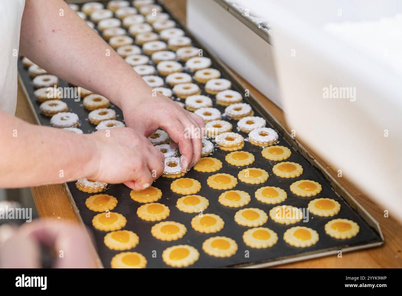 Zweihändig dekorieren zweilagige runde Kekse auf einem Backblech, Weihnachtsbacken, Schwarzwald, Deutschland, Europa Stockfoto