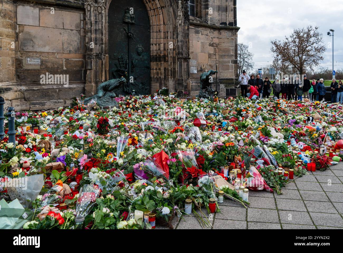 Magdeburg Deutschland 22. Dezember 2024: Nach dem Angriff auf den Weihnachtsmarkt trauern Menschen und legen Blumen, Kerzen und Kuschelspielzeug ab. Stockfoto