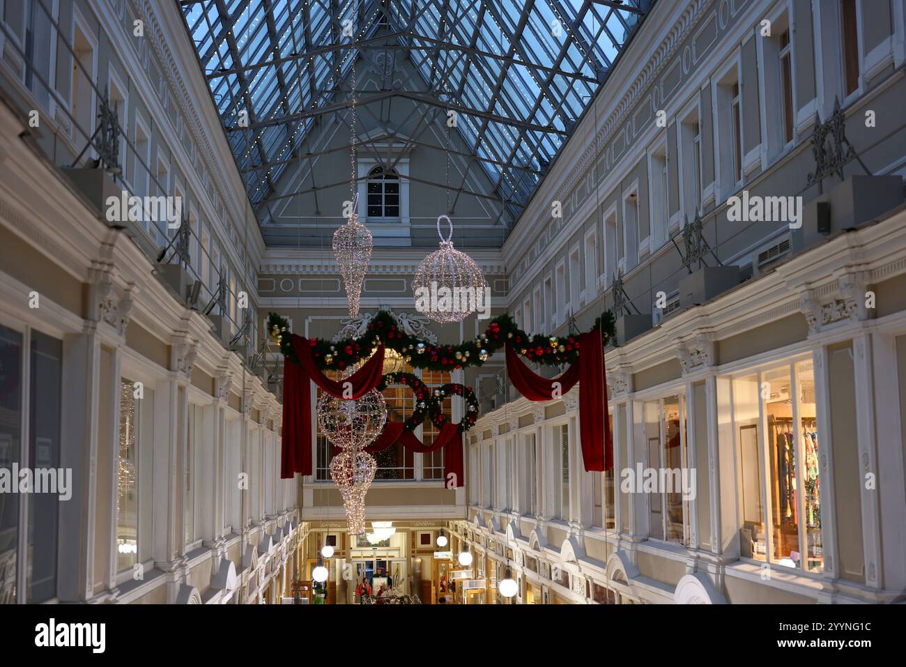Im Zentrum der Stadt zieren festliche Dekorationen eine elegante Einkaufspassage mit atemberaubender Architektur Stockfoto