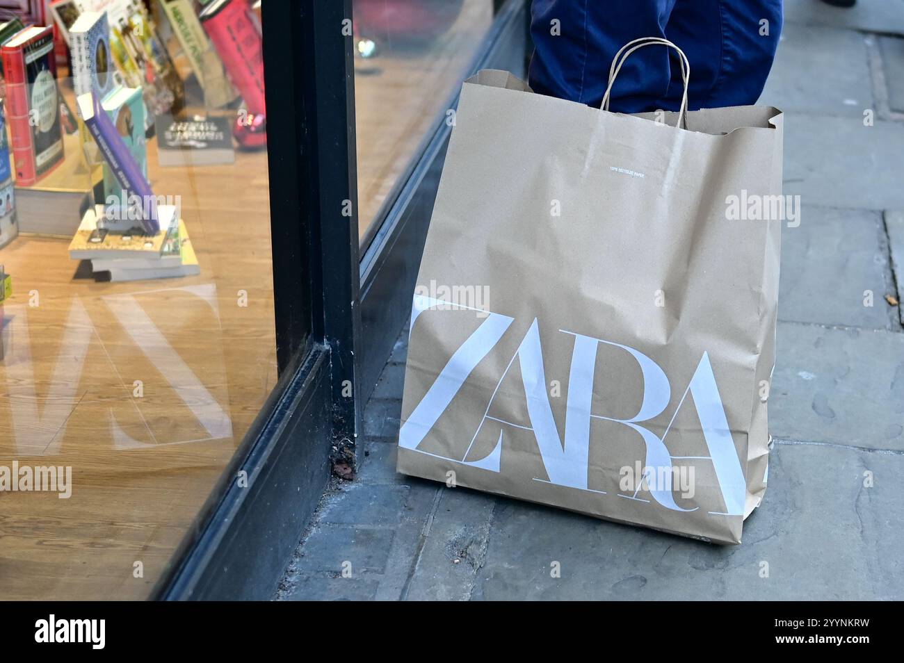 Cambridge, England, 22. Dezember 2024, Zara Papiertüte mit Branding auf dem Boden in der Stadtstraße Stockfoto
