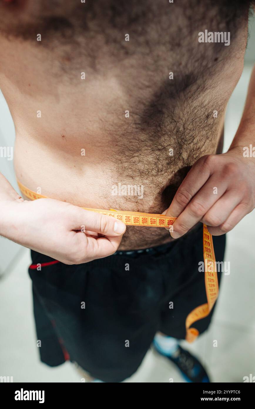 Die Messung der Taillengröße ist entscheidend, um die gewünschten Fitnessziele zu erreichen Stockfoto