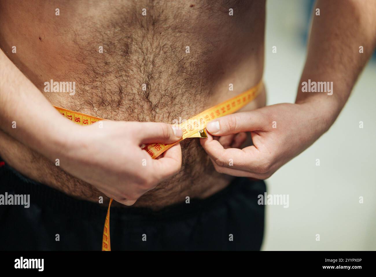 Die Messung der Taille ist ein wichtiger Aspekt für Fitness und Gesundheit Tracking und Monitoring Fortschritt Stockfoto