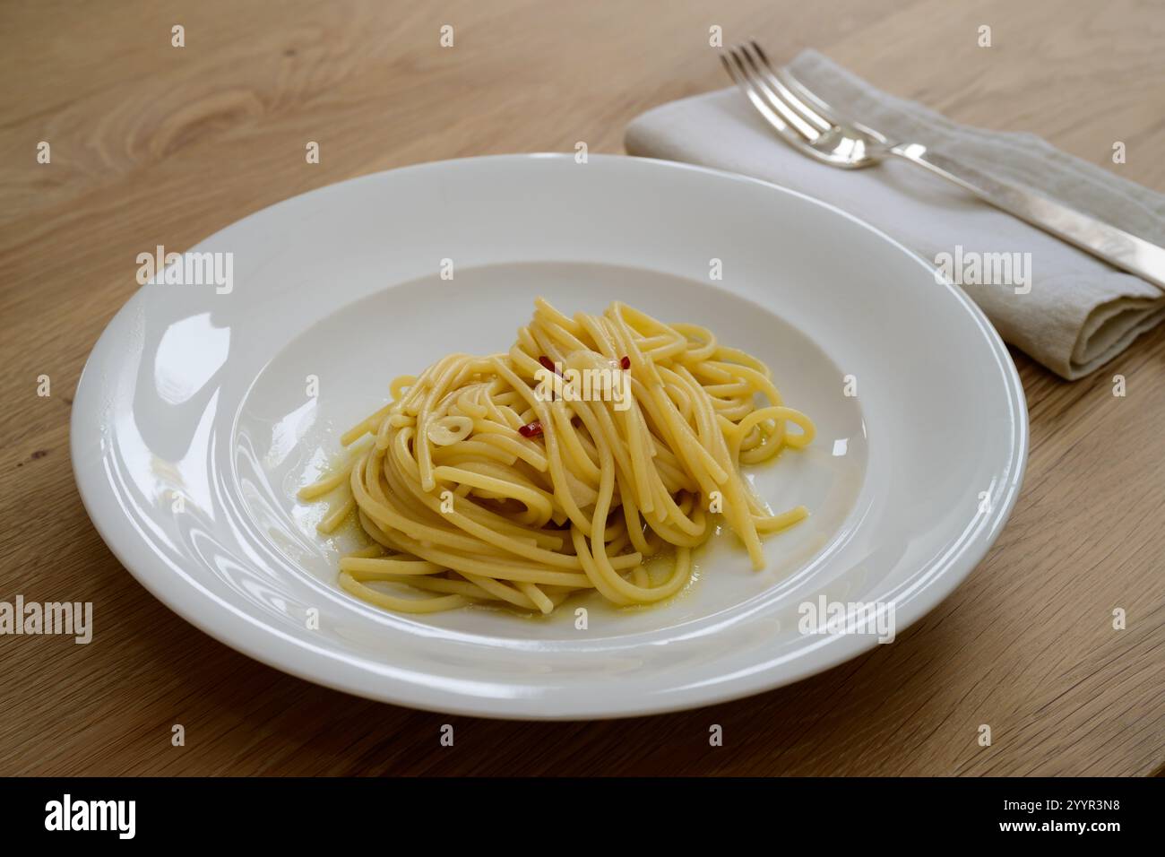 Spaghetti Colatura di Alici mit Knoblauch und Peperoncini auf einer weißen Platte Stockfoto
