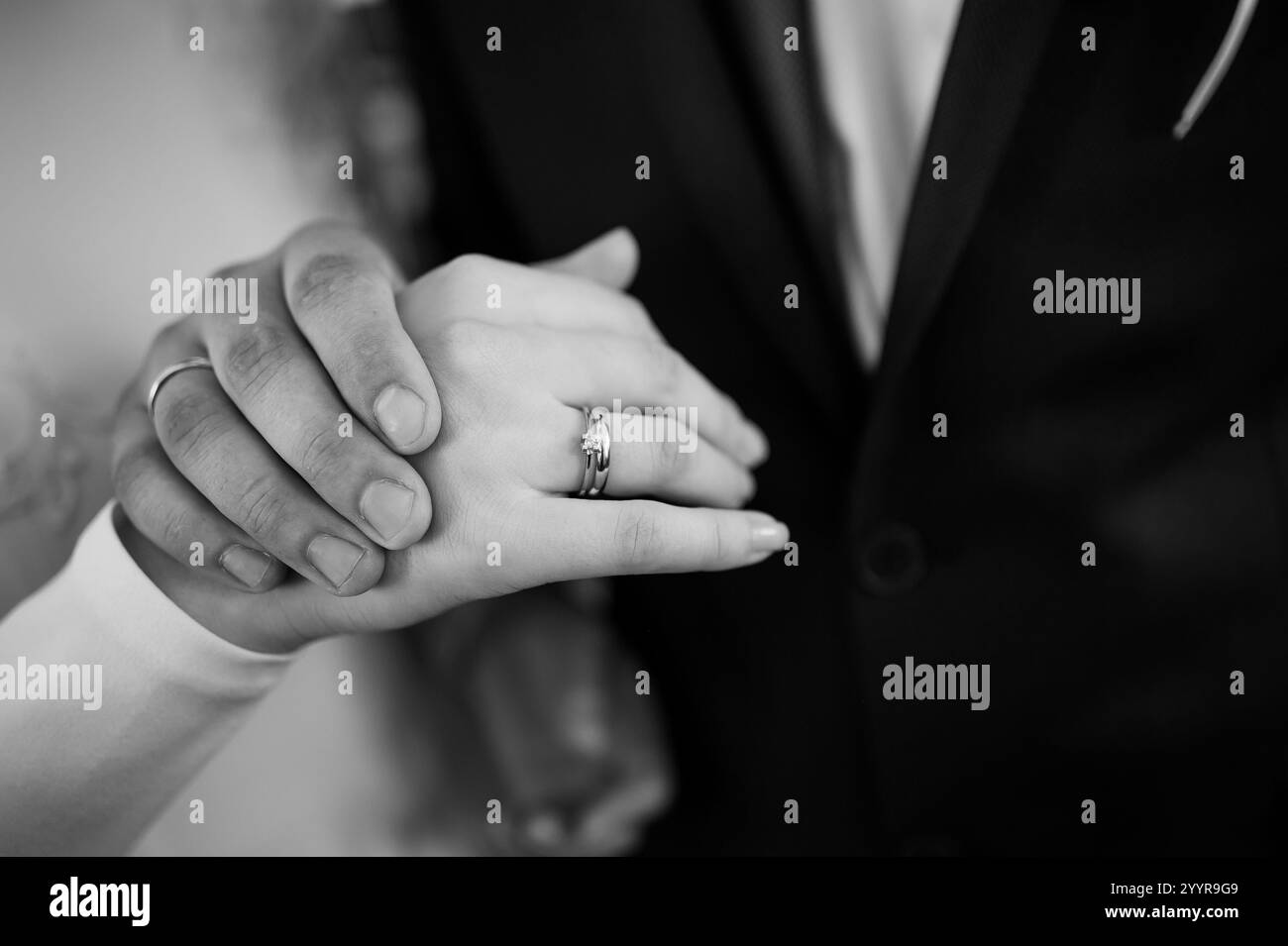 Emotionaler Austausch von Hochzeitsringen in Schwarz-weiß. Stockfoto