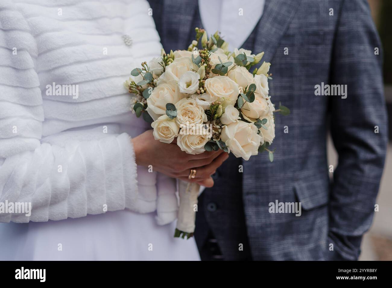 Eleganter Brautstrauß in weichen Pastelltönen mit dem Anzug des Bräutigams. Stockfoto