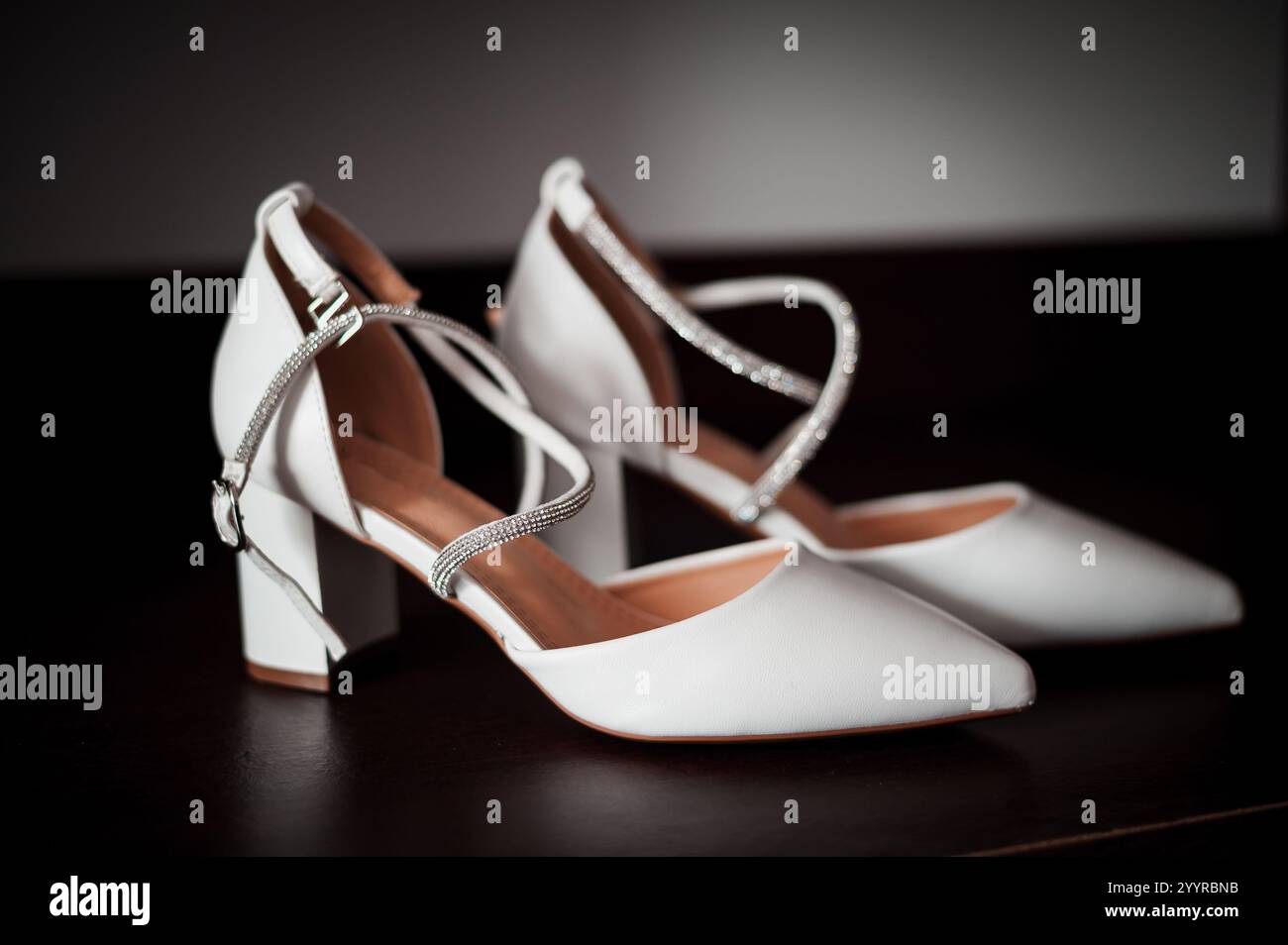 Elegante weiße Schuhe mit Blockabsatz und dekorativen Trägern. Stockfoto