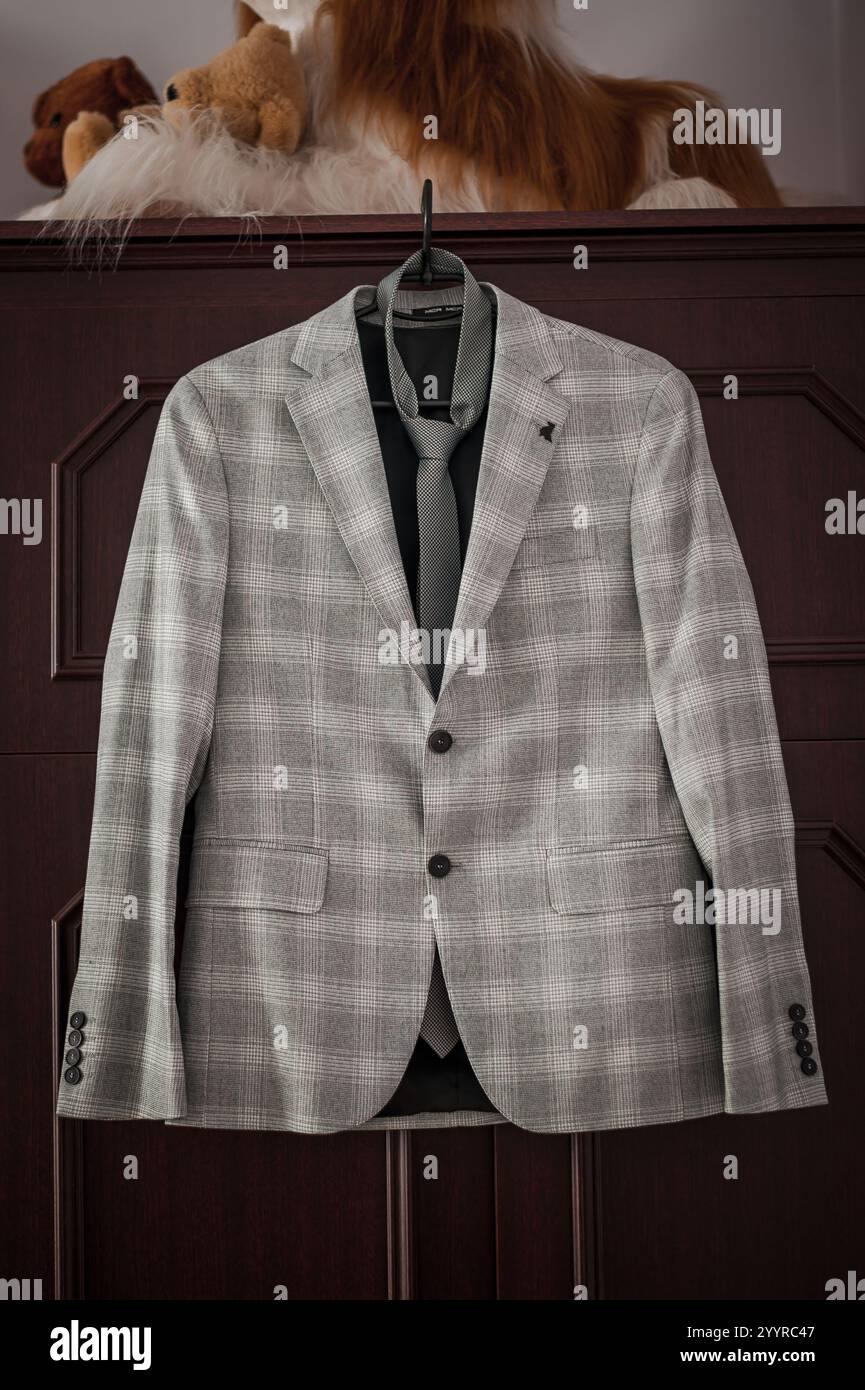 Eleganter Anzug mit grauem Karomuster und Krawatte auf hölzernem Hintergrund. Stockfoto