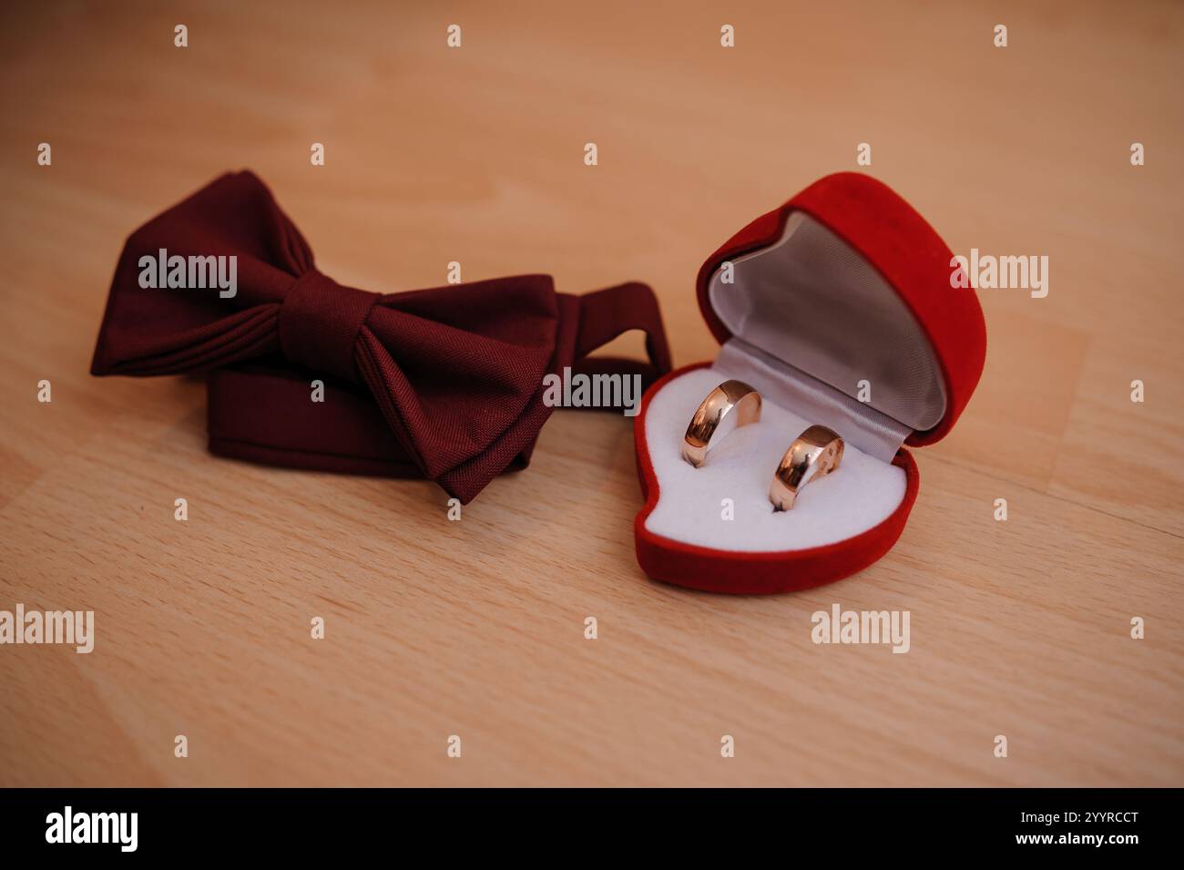 Romantische Hochzeitsringe und elegante Bowtie auf hölzernem Hintergrund. Stockfoto