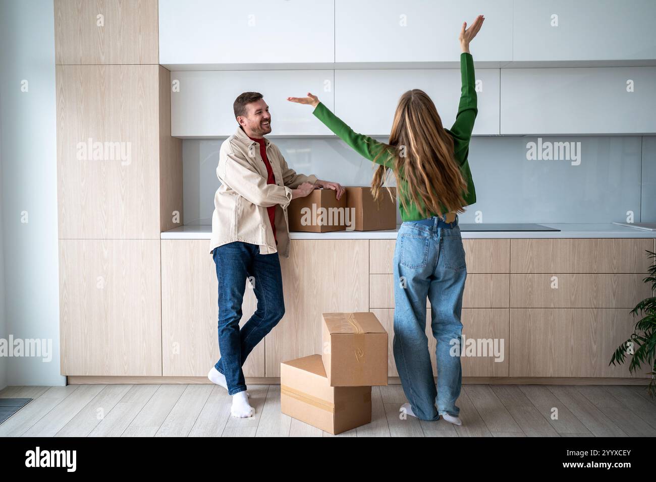 Eine überglückte Frau und eine glückliche Umsiedlung des Mannes. Lange erwartete Wohnung mit genehmigter Hypothek. Stockfoto