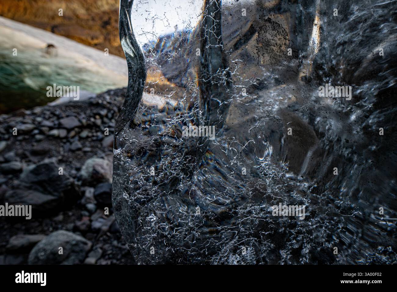 Die schimmernde Eisoberfläche fängt die umliegende Landschaft ein, während das Dämmerlicht das Gletschertal beleuchtet und felsige Details und eisige Formationen enthüllt. Stockfoto