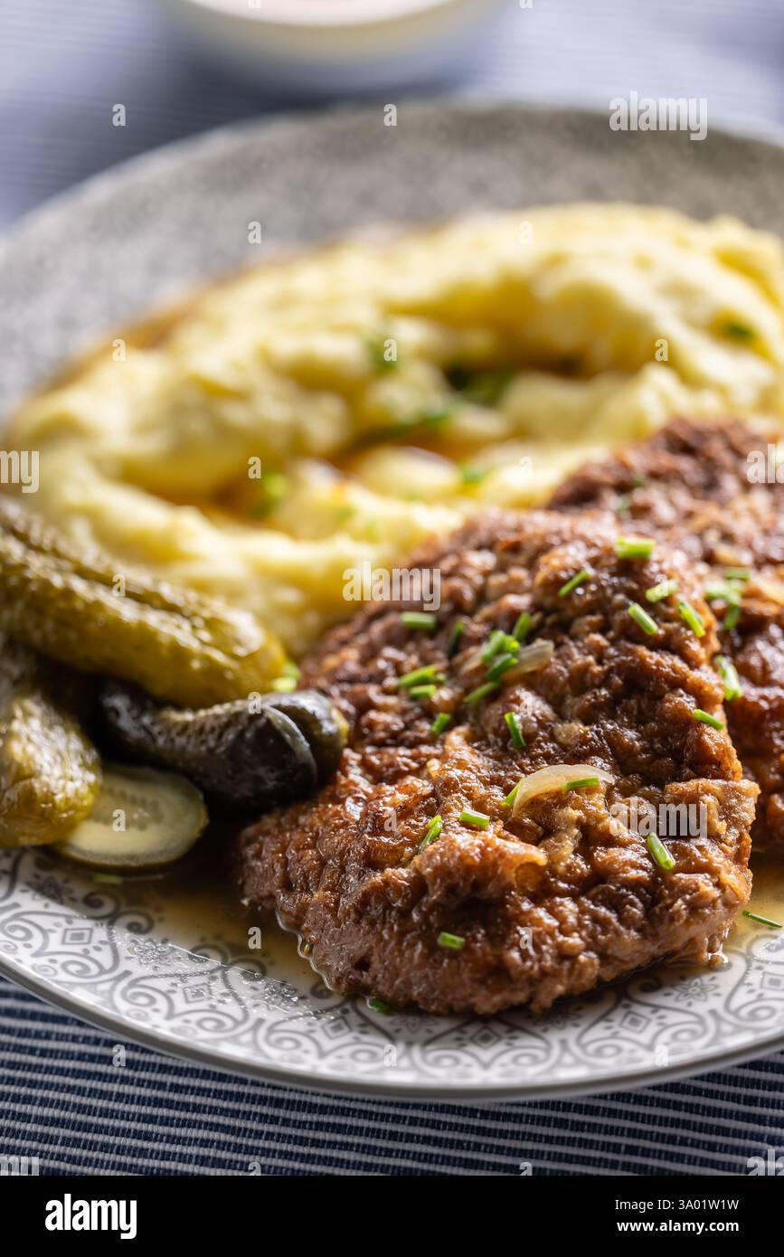 Inverted Beef Schnitzel mit Kartoffelpüree und eingelegten Gurken. Traditionelle tschechische und slowakische Küche Stockfoto