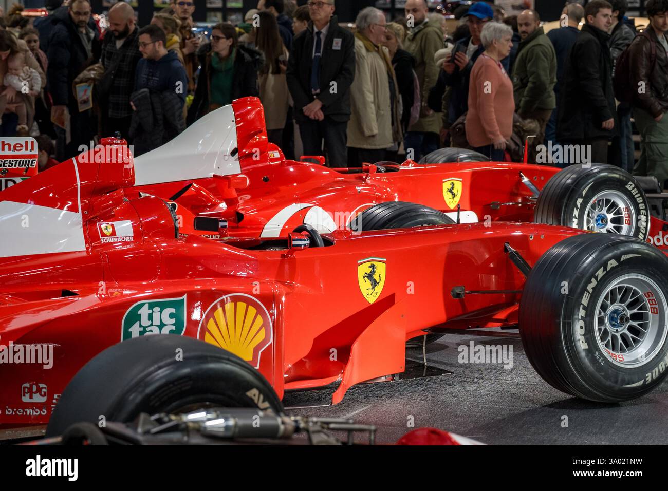 Bei einer belebten Autoshow mit legendären Rennwagen, die in einer Vielzahl von leidenschaftlichen Enthusiasten zu sehen sind, erfüllt die Spannung die Luft Stockfoto
