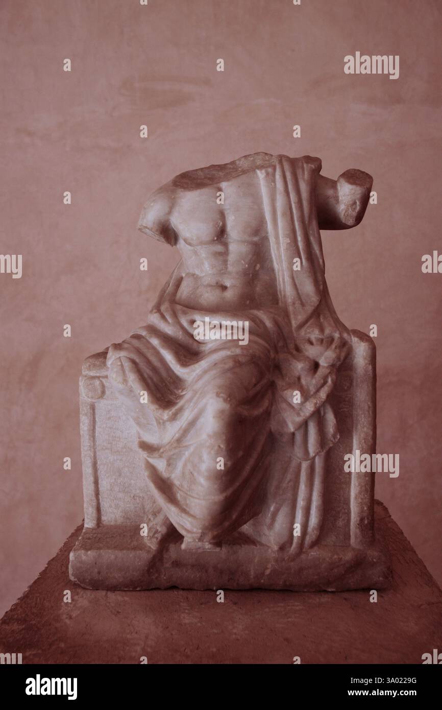 Kopflose hellenistische Zeus-Statue, gekennzeichnet durch den Kultnamen „Nikephoros“ (Siegesbringer) aufgrund des Attributs, das in der erhobenen rechten Hand im archäologischen Museum von Umm Qais an der antiken Stätte von Gadara (Umm Qays) zu sehen ist, das während der hellenistischen und römischen Zeit ein Zentrum der griechischen Kultur in der Region war. Im Nordwesten Jordaniens Stockfoto