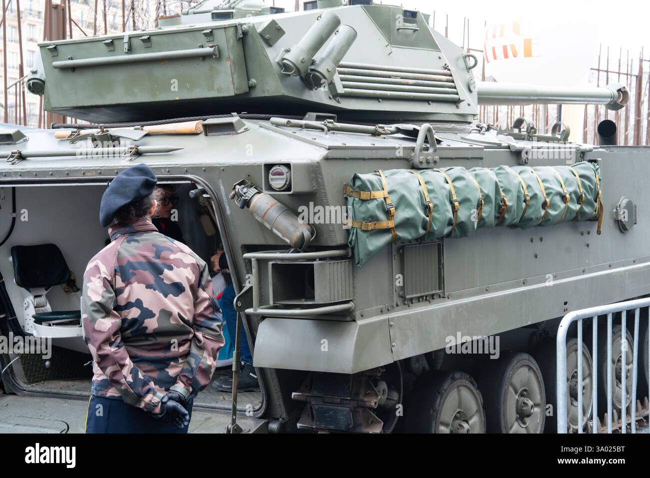 Militärangehörige untersuchen gepanzerte Fahrzeuge auf einer städtischen Ausstellung, in der Verteidigungstechnologie und historische Militärausrüstung gezeigt werden Stockfoto