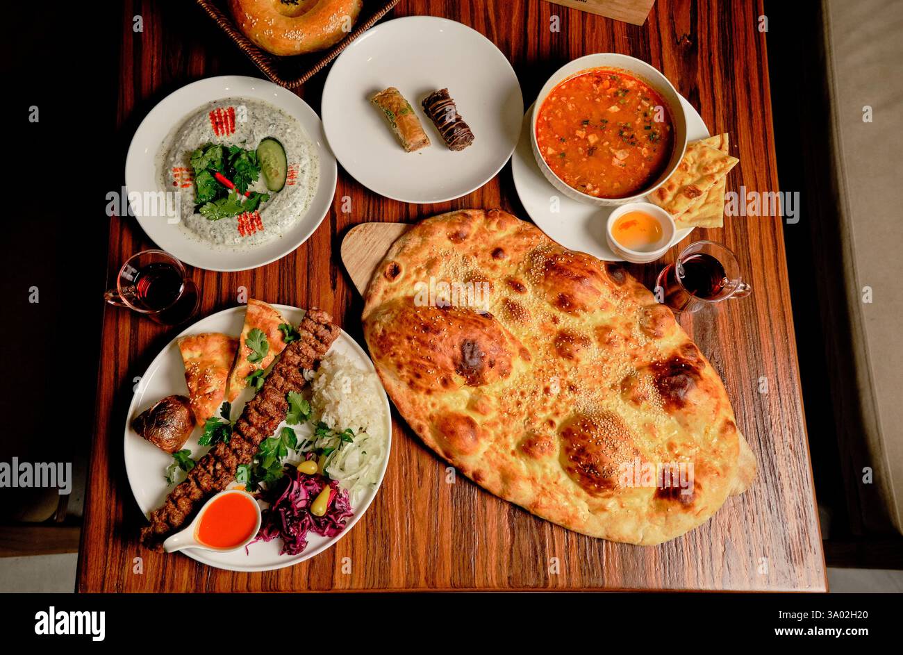 Ein traditionelles türkisches Menü: Ballon Lavash, Haydari Dip, Adana Kebab mit Beilagen, Baklava (klassisch und Schokolade) und Suppe Stockfoto