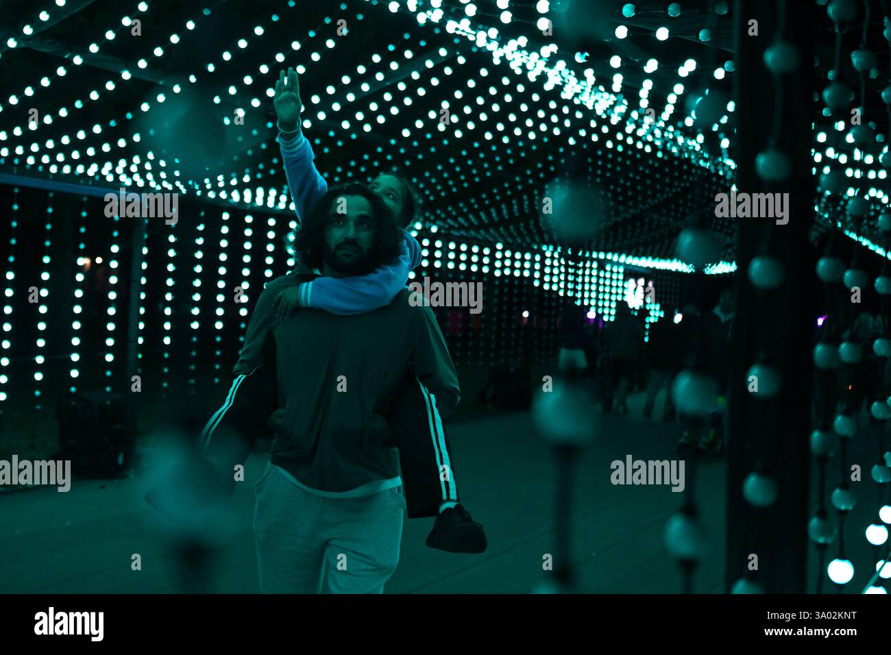 Canberra, Australien. März 2025. Ein Vater trägt seine Tochter, während sie durch eine Lichtinstallation beim Canberra 2025 Enlighten Festival am Sonntag, den 2. März 2025, in Canberra spazieren. (AAP Image/Lukas Coch) KEIN ARCHIVIERUNGSGUTSCHEIN: Australian Associated Press/Alamy Live News Stockfoto