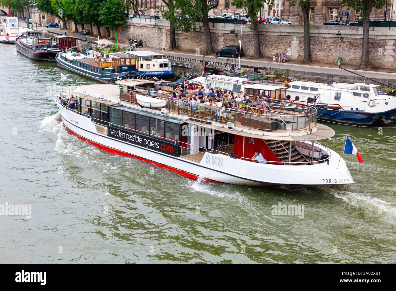 Paris, Frankreich - 21. Juli 2010 : Boote am Südufer der seine. Die Bootstour fährt in der Nähe von vertäuten Booten vor dem Quai de Conti (Straße). Stockfoto