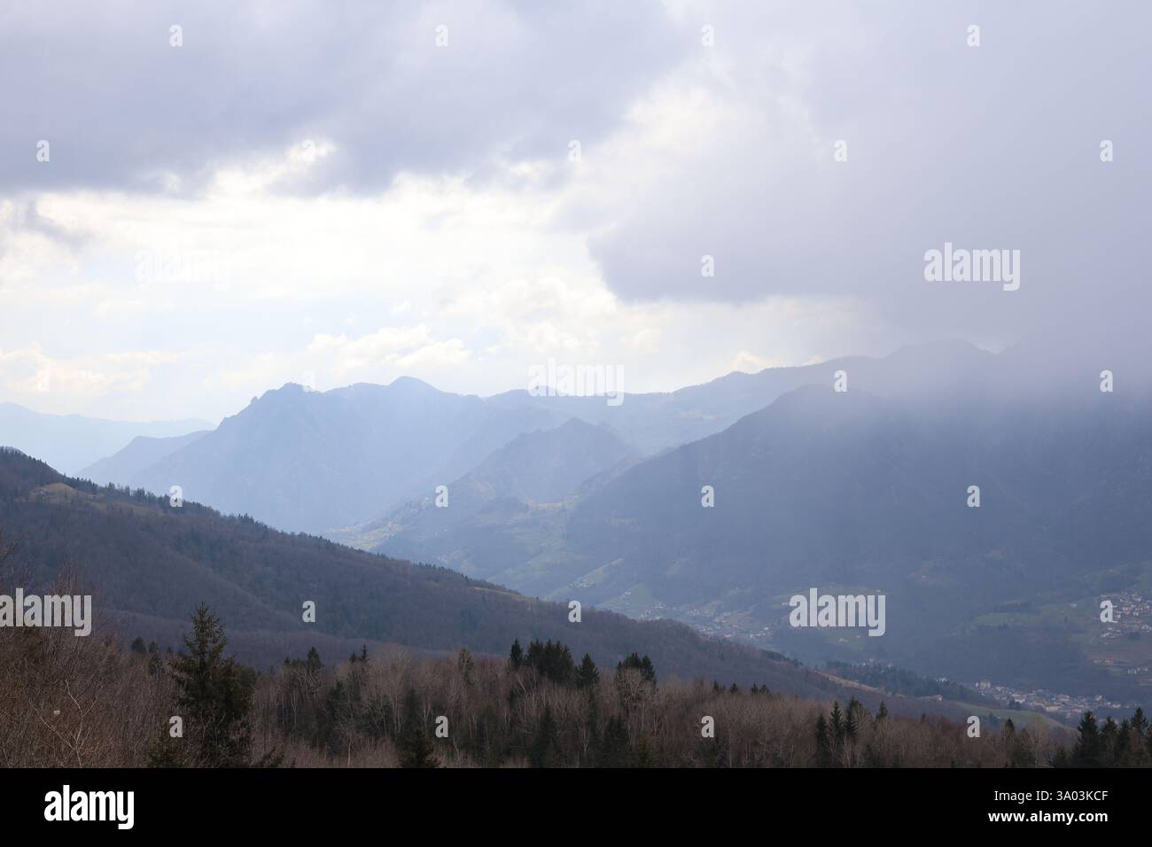 Berglandschaft, die die Alpen in Italien zeigt, in der Nähe der Stadt Dossena, mit Nebel und schlechter Sicht Stockfoto