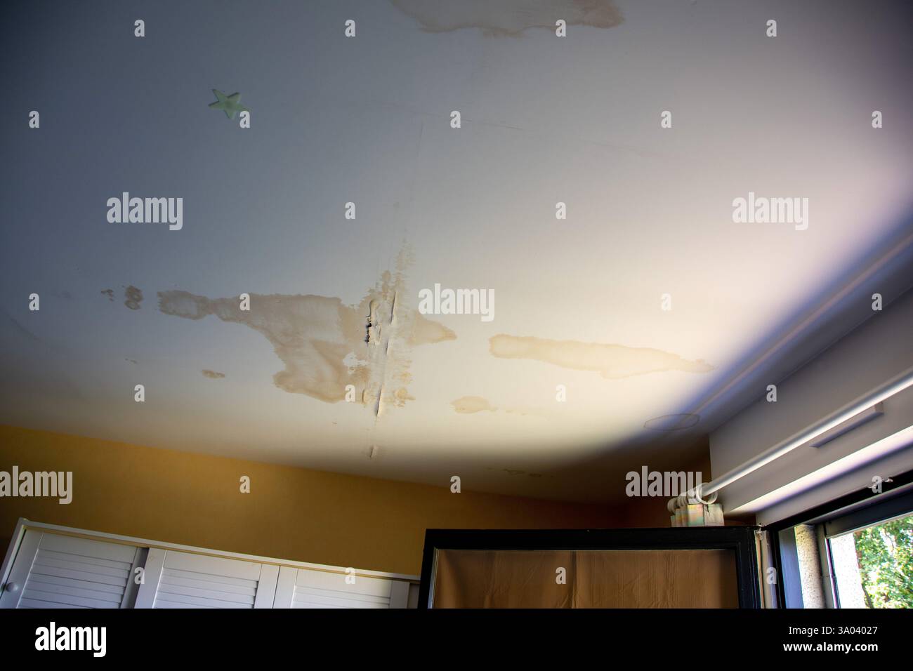 Wasserschäden an der Decke, die auf ein potenzielles Leck in Wohnräumen hinweisen Stockfoto