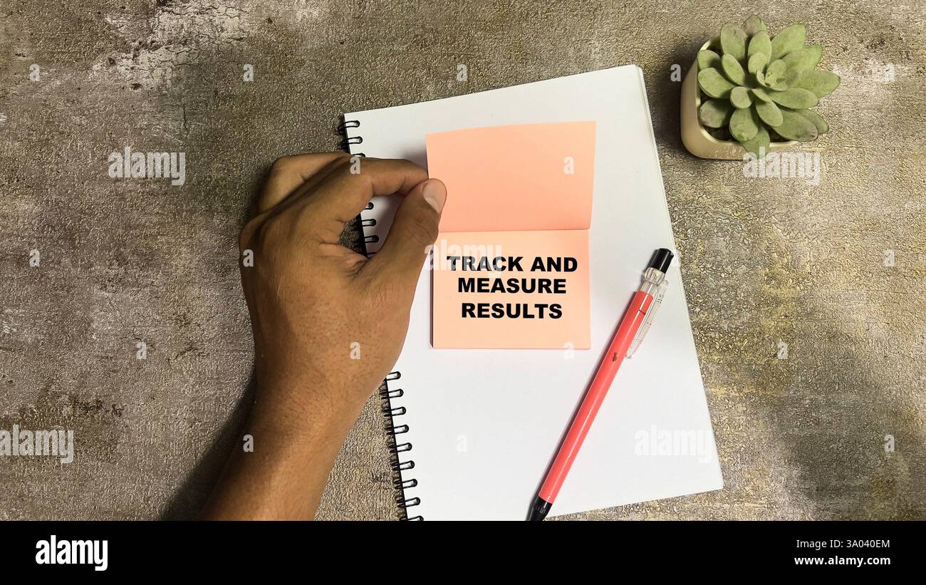 Konzept der Ergebnisse von Track and Measure Schreiben Sie auf Haftnotizen, die auf Holztisch isoliert sind. Stockfoto