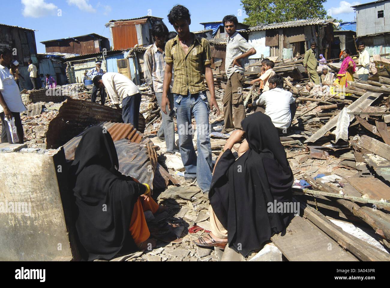 Slum-Bewohner sitzen mit ihren Habseligkeiten nach Abriss der Slums auf Sahar Flughafen Chatrapati Shivaji International airport Stockfoto