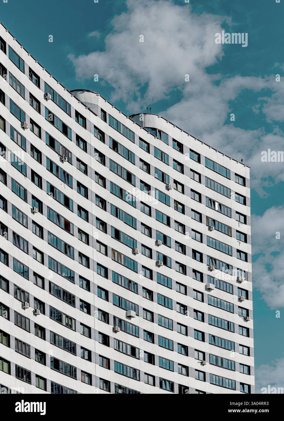 Neue Hochhausarchitektur in sich entwickelnder Stadtstadt. Mehrstöckiges Wohngebäude mit Betonfassade, großen Fenstern und Klimaanlage Stockfoto
