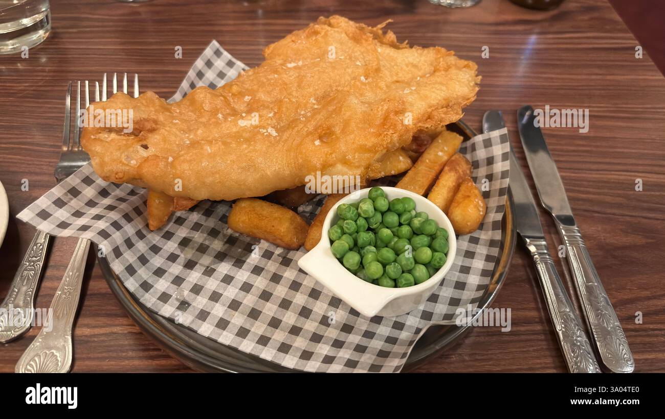 Klassisches Fish and Chips serviert mit Erbsen - britische Küche - Smartphone-aufgenommenes Stockfoto