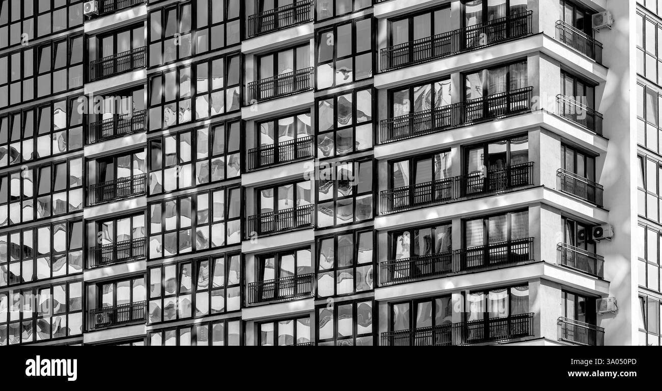 Modernes Hochhausgebäude im Stadtteil. Hohe Wohnanlage mit grauer Betonfassade und großen Fenstern. Neuentwicklung bei einem Growi Stockfoto