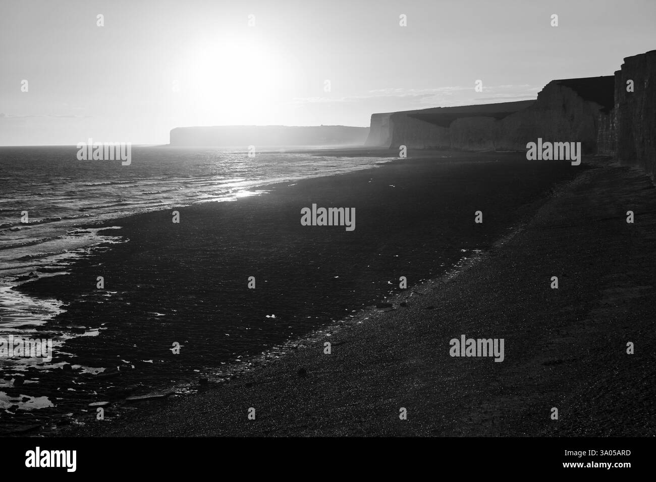 Sonnenuntergang am Kieselstrand, Kreidefelsen der Sieben Schwestern, Hintergrundbeleuchtung, Schwarzweiß, Birling Gap, East Sussex, South Downs, England, Großbritannien Stockfoto