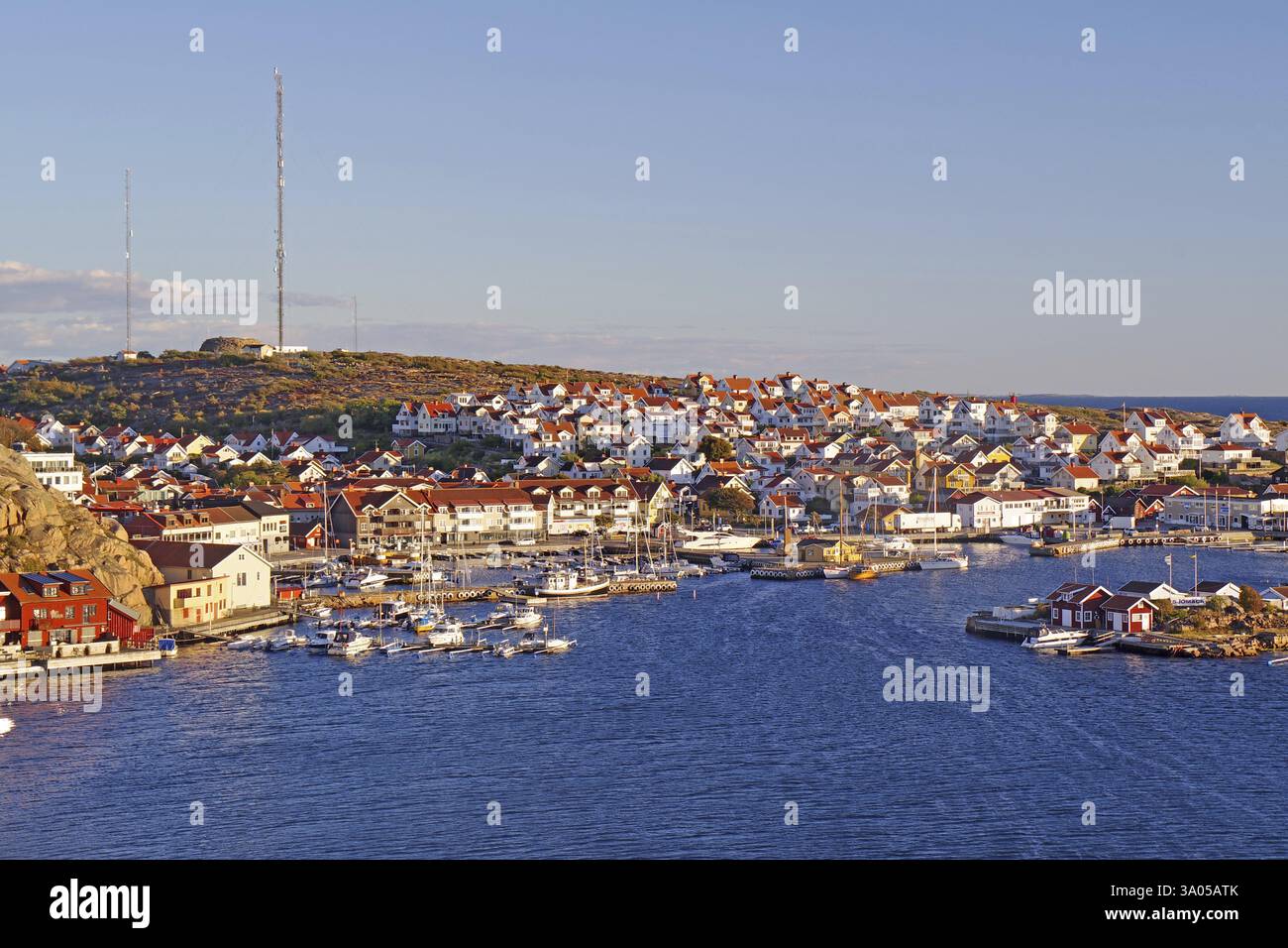 Hafenstadt mit vielen Booten und weißen Häusern auf einem Hügel bei Sonnenuntergang, Archipel Küste, Smoegen, Bohuslaen, Schweden, Europa Stockfoto