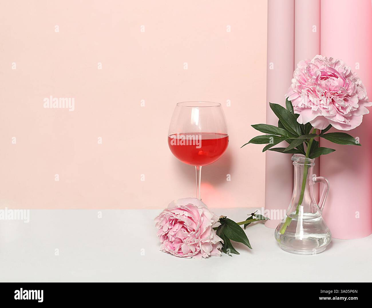 Modernes Stillleben mit Rosenwein, alkoholischem Cocktail und Pfingstrosenblüten auf elegantem modernem Hintergrund, minimales Konzept für Bar, Café, Werbebanner Stockfoto