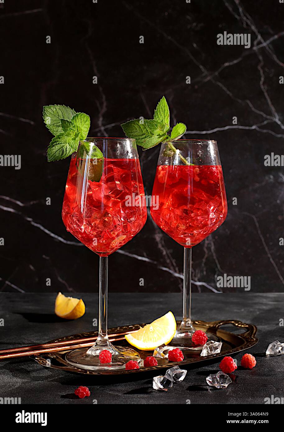 Königlicher alkoholischer Limonade-Cocktail mit Limette, Eis und frischen Himbeeren, Bar- und Partykonzept, Restaurant- und Café-Werbekarte, schwarzer Hintergrund, Stockfoto