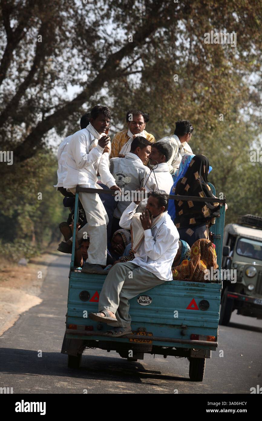 Eine Gruppe von Personen, die hinter einem Dreirad-Roller sitzen und auf der Autobahn in Richtung Ahmedabad, Gujarat, Indien, Asien gesehen werden Stockfoto