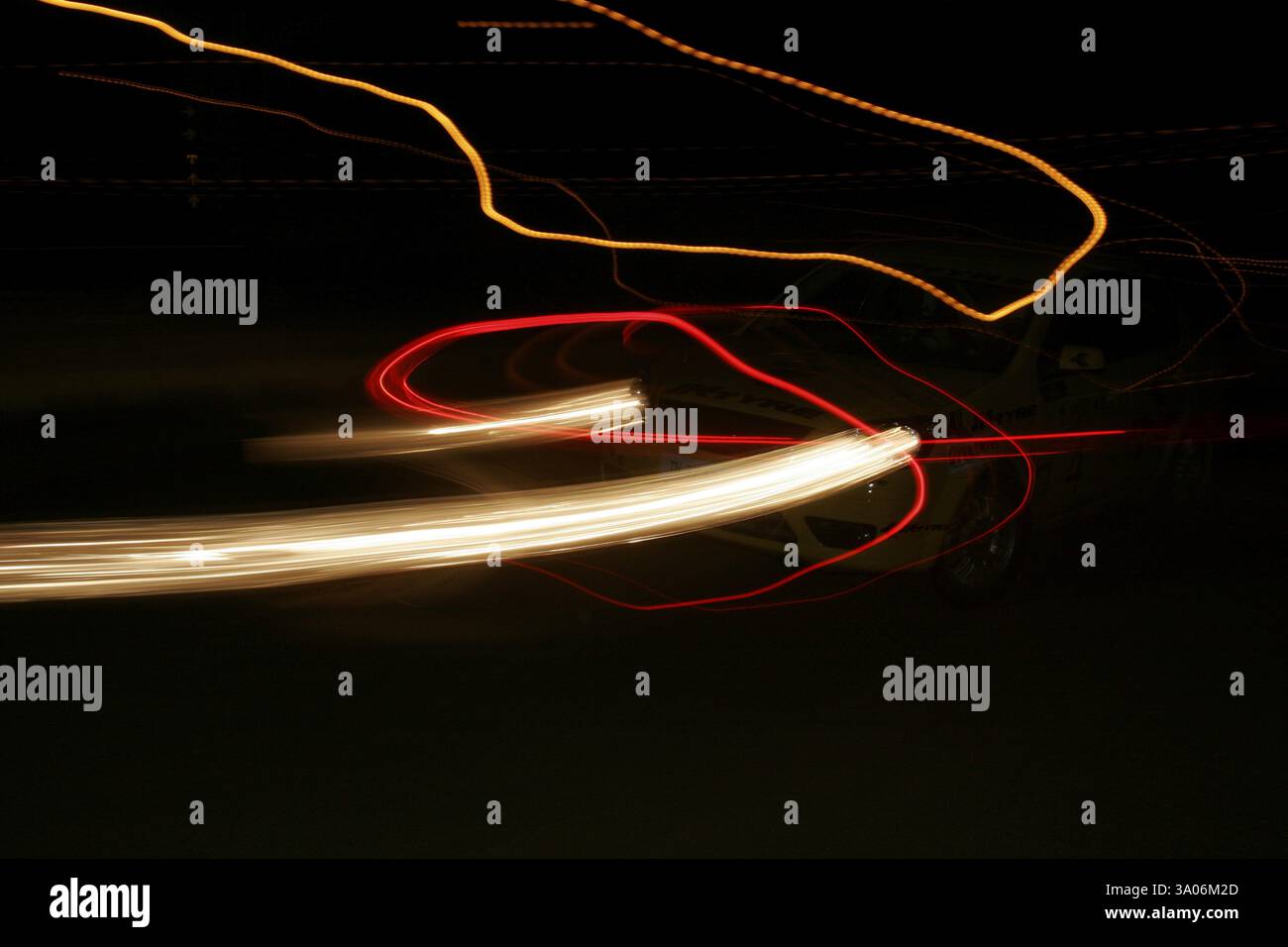 Streifen von Kopf- und Rücklichtern von rasanten Autos und Straßenlaternen in der Nacht beim Rennen im Balewadi Sportkomplex, Pune, Maharashtra, Indien, KEIN MR Stockfoto