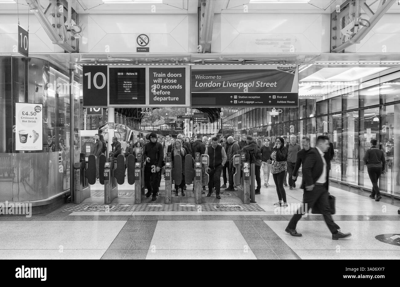 Pendler/Passagiere, die während der morgendlichen Hauptverkehrszeit die automatischen Fahrkartenschranken am Bahnhof London Liverpool Street passieren Stockfoto