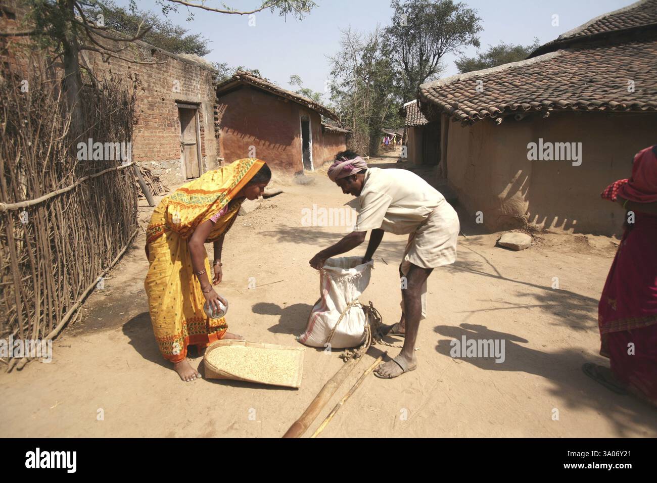 Die Dame kauft Getreide von einem traditionellen Händler im Austausch gegen alte Sachen im Dorf in Jharkhand, Indien, KEIN MR Stockfoto