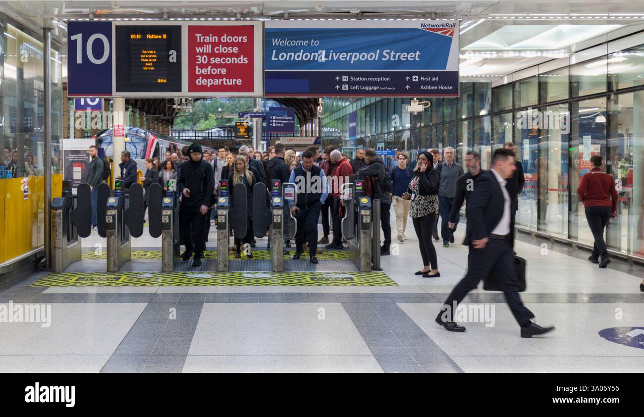 Pendler/Passagiere, die während der morgendlichen Hauptverkehrszeit die automatischen Fahrkartenschranken am Bahnhof London Liverpool Street passieren Stockfoto