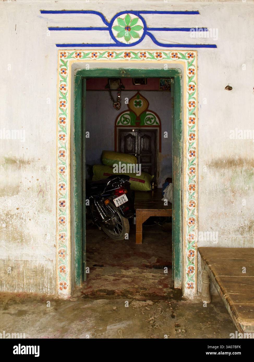 Dekorierte Tür eines Hauses in Bakraur, in der Nähe von Bodh Gaya, Bihar, Indien, mit Blumenmotiven und einem traditionellen Eingangsdesign. Stockfoto